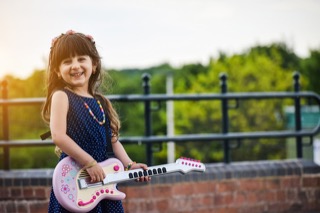 young girl learning to play the guitar
